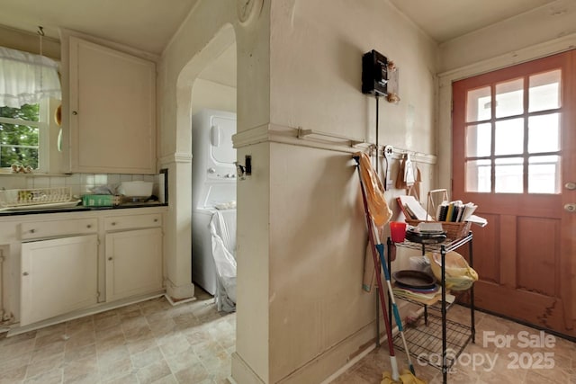 interior space featuring dark countertops, arched walkways, and tasteful backsplash