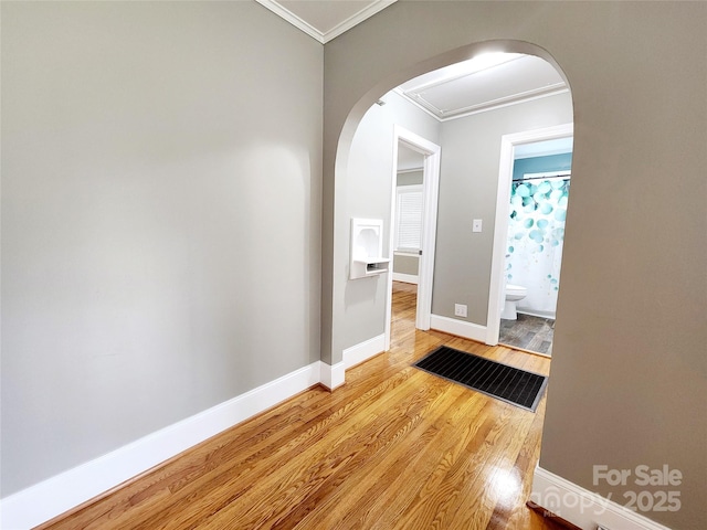 501 N Hawthorne St, Mount Holly, NC 28120 - corridor with baseboards, arched walkways, wood finished floors, and crown molding