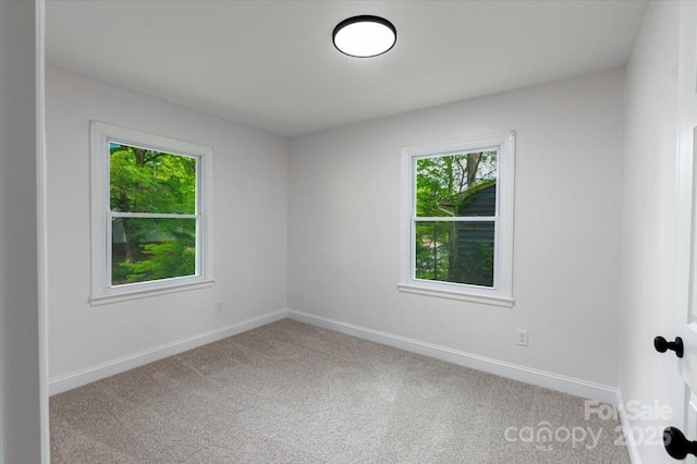 spare room featuring baseboards and carpet