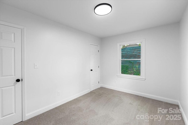 carpeted spare room with baseboards