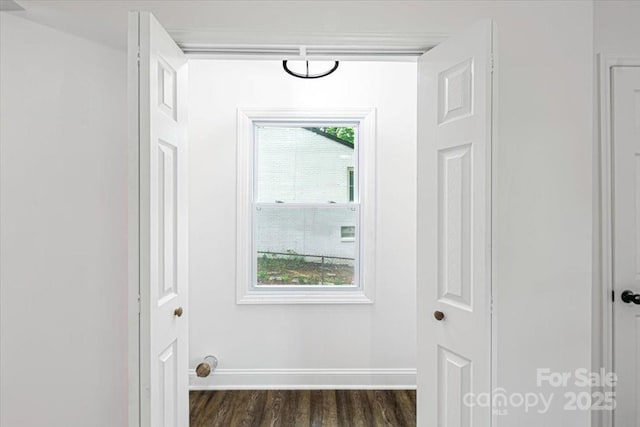 entryway featuring baseboards and dark wood-style floors