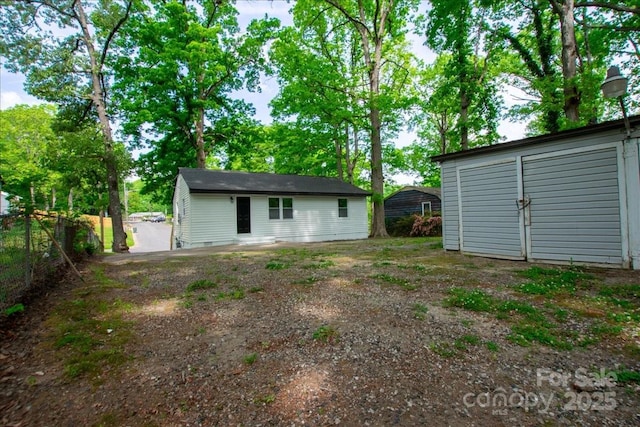 back of property with fence and an outdoor structure