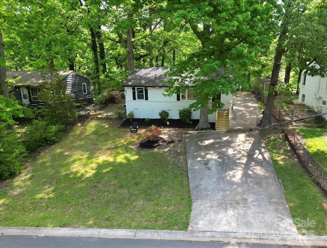 view of front facade featuring driveway and a front yard