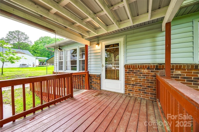 wooden terrace featuring a yard