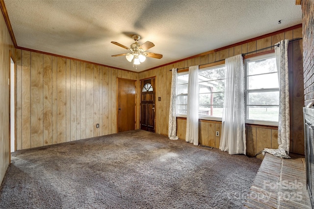 unfurnished room with ceiling fan, a healthy amount of sunlight, crown molding, and carpet floors