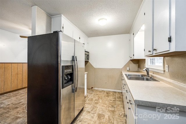 kitchen featuring a sink, light countertops, a textured ceiling, white cabinets, and appliances with stainless steel finishes