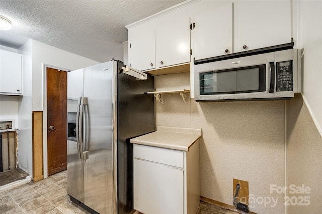kitchen with open shelves, appliances with stainless steel finishes, light countertops, white cabinetry, and a textured ceiling