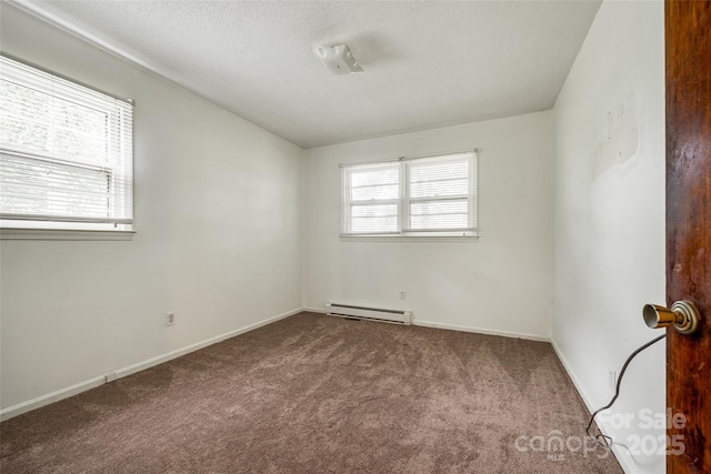 carpeted empty room with baseboards, a baseboard heating unit, and a textured ceiling
