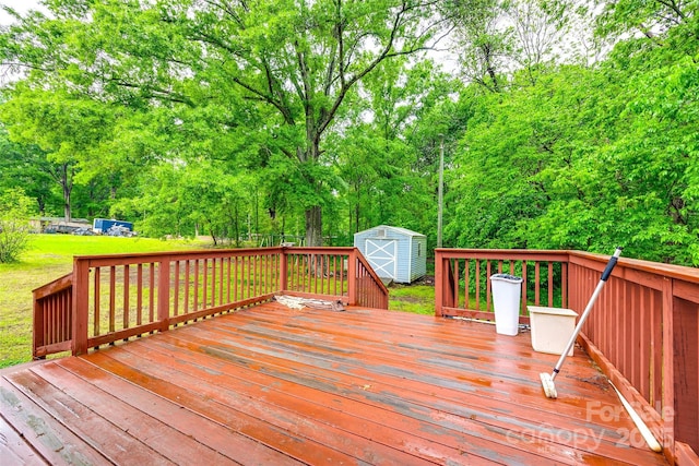 wooden deck featuring an outdoor structure, a shed, and a lawn