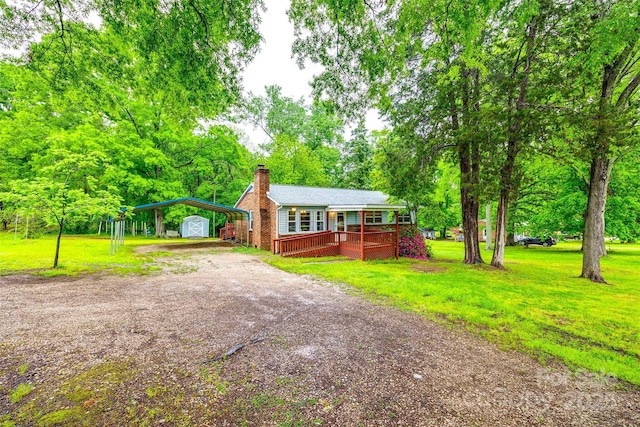 view of front of home featuring a front lawn, a deck, dirt driveway, and a chimney