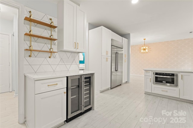 kitchen featuring white cabinetry, open shelves, stainless steel appliances, light countertops, and wine cooler