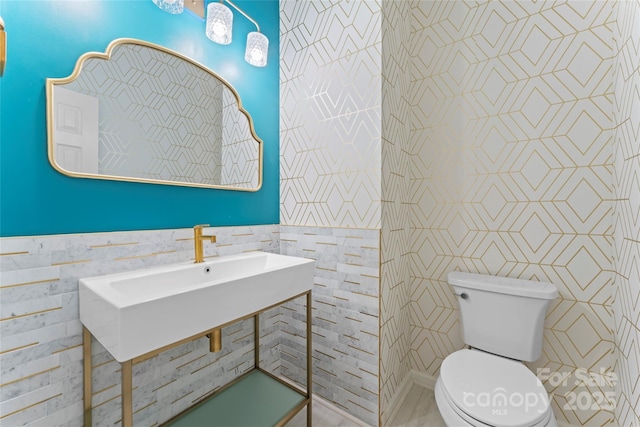 half bathroom featuring tile walls and toilet