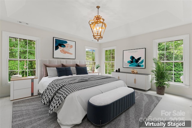 bedroom with visible vents, an inviting chandelier, and a tray ceiling