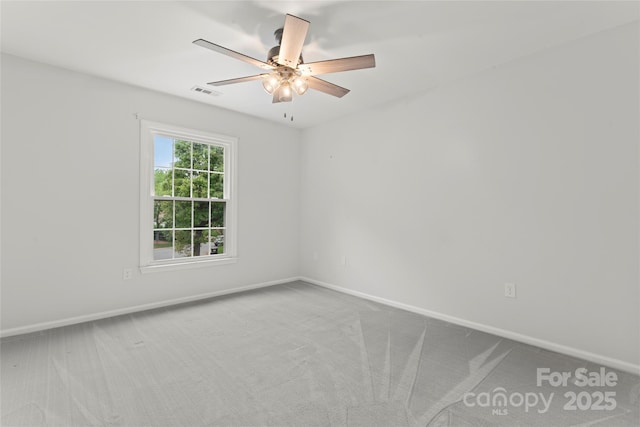 spare room with baseboards, visible vents, ceiling fan, and carpet