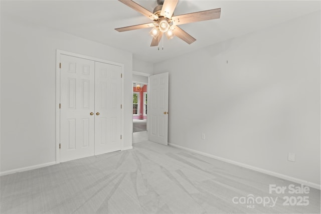 unfurnished bedroom with baseboards, a closet, and light colored carpet