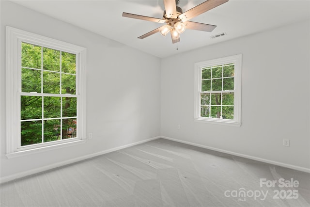 unfurnished room featuring visible vents, light colored carpet, and baseboards