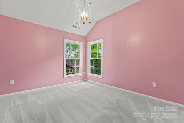 carpeted empty room with lofted ceiling, visible vents, a chandelier, and baseboards