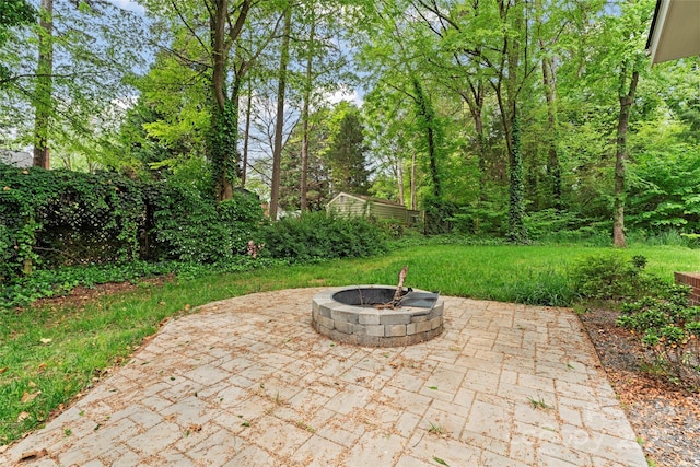 view of patio with an outdoor structure, a storage shed, and a fire pit