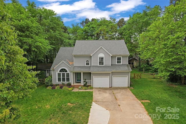 traditional home featuring fence, a shingled roof, a garage, driveway, and a front yard