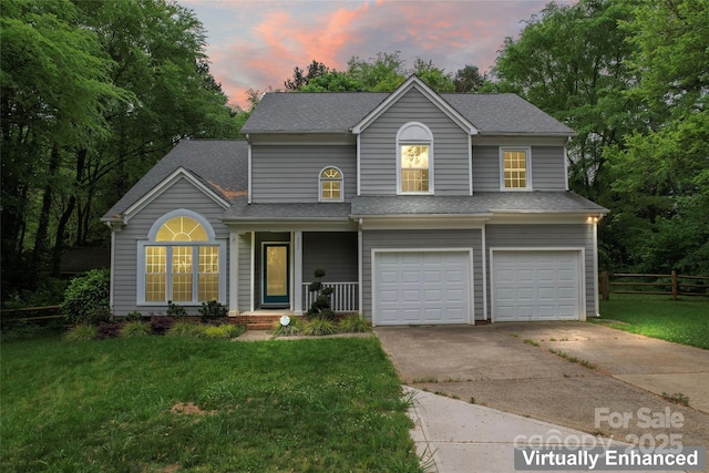 view of front facade with a garage, fence, driveway, and a yard