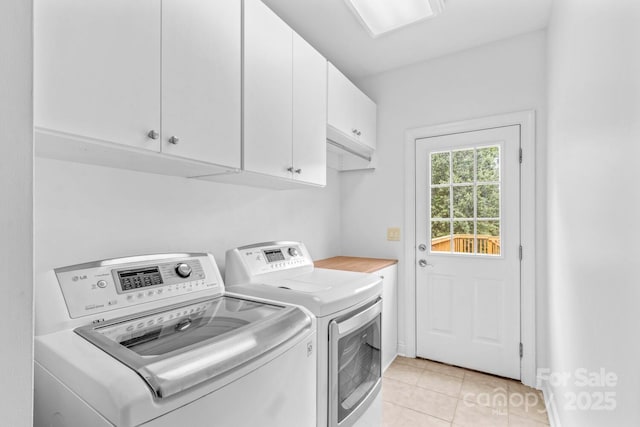 clothes washing area with cabinet space, independent washer and dryer, and light tile patterned floors
