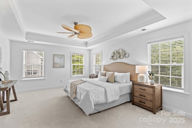 bedroom featuring ceiling fan, crown molding, a raised ceiling, baseboards, and light carpet