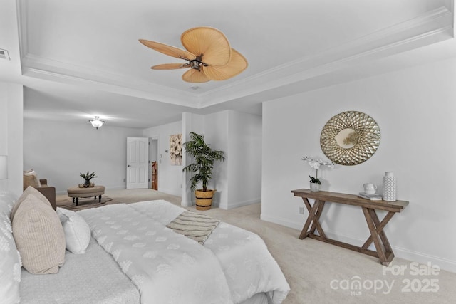 bedroom with carpet floors, ornamental molding, a tray ceiling, and visible vents