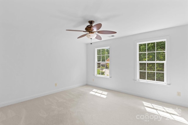 unfurnished room with a ceiling fan, baseboards, visible vents, and light carpet