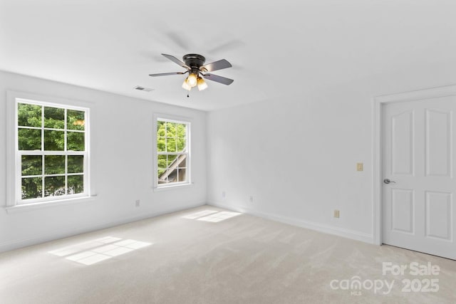 spare room featuring baseboards, a ceiling fan, carpet flooring, and visible vents