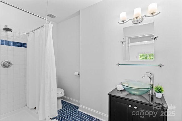 full bath with vanity, tile patterned flooring, a tile shower, and toilet