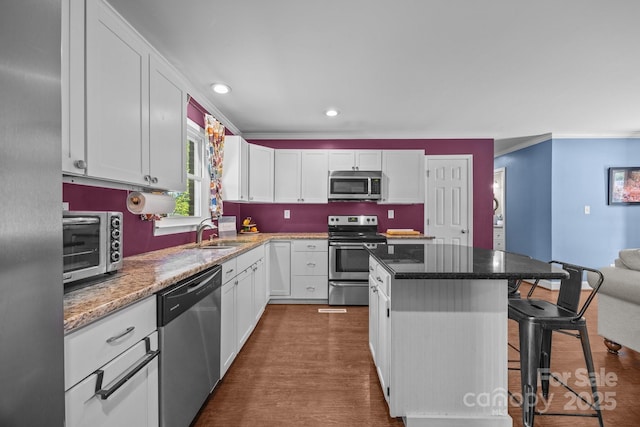 250 Log Barn Rd, Salisbury, NC 28146 - kitchen with a breakfast bar area, a kitchen island, appliances with stainless steel finishes, a sink, and white cabinets