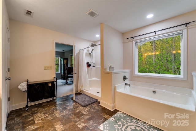 bathroom featuring baseboards, a shower stall, a bath, and visible vents