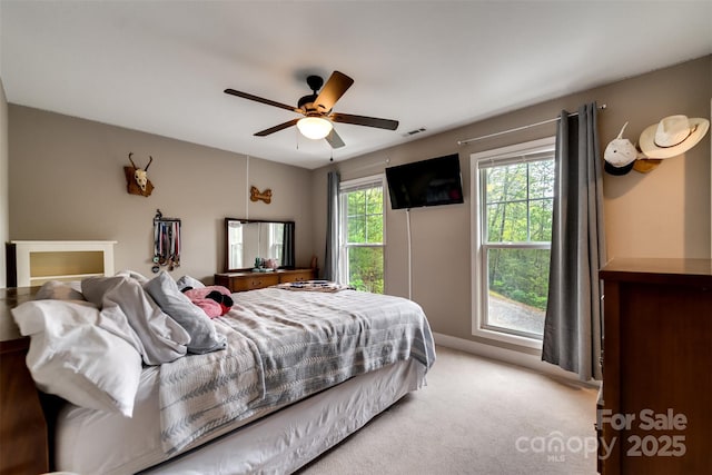 bedroom featuring visible vents, baseboards, ceiling fan, and light carpet