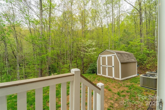 view of shed with central AC unit and a wooded view