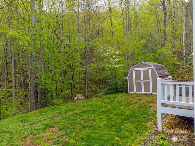 view of yard with a storage shed, an outdoor structure, central air condition unit, and a forest view