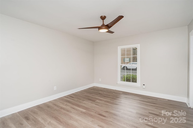 empty room with wood finished floors, ceiling fan, and baseboards