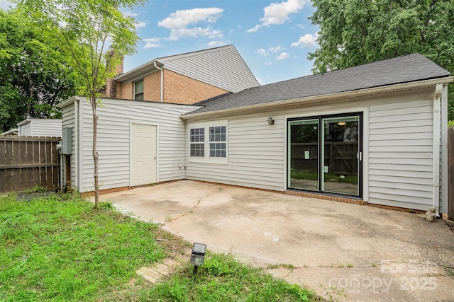 back of house featuring fence, a patio area, and a shingled roof