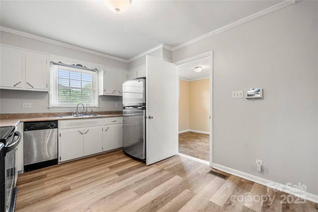 115 K M Murphy Rd, Gastonia, NC 28056 - kitchen featuring light wood-style flooring, stainless steel appliances, white cabinets, ornamental molding, and a sink