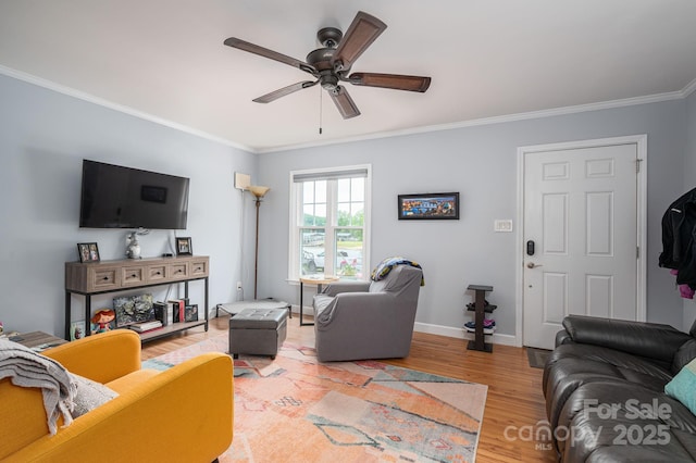living area with crown molding, baseboards, a ceiling fan, and wood finished floors
