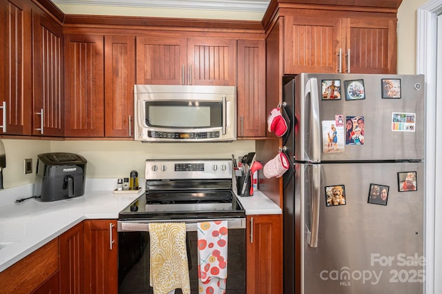 kitchen with light countertops, appliances with stainless steel finishes, and brown cabinetry
