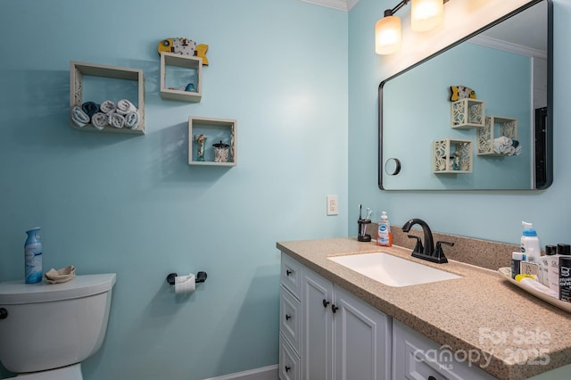 bathroom featuring crown molding, baseboards, toilet, and vanity