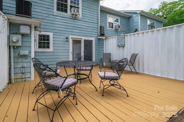 wooden deck featuring french doors, outdoor dining space, and cooling unit