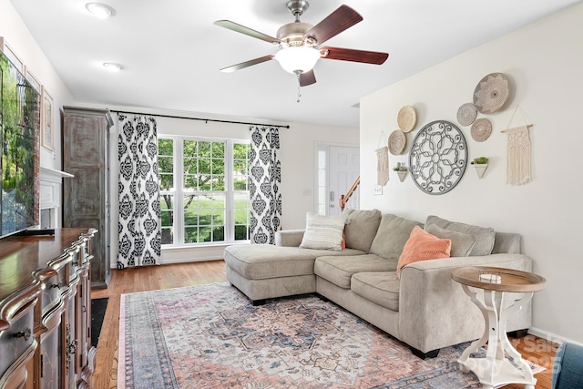 living area with a ceiling fan and light wood-style floors