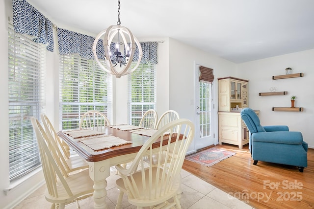 dining room with baseboards, a notable chandelier, and light tile patterned floors