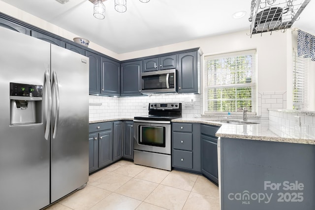 kitchen featuring a sink, light tile patterned floors, light stone countertops, decorative backsplash, and appliances with stainless steel finishes