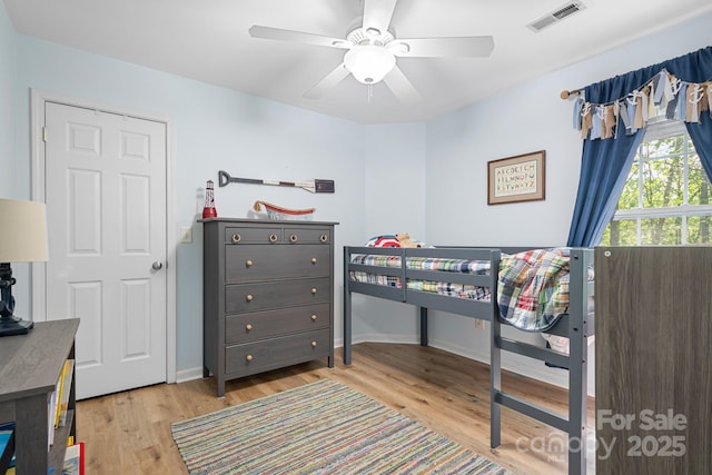 bedroom featuring baseboards, light wood-style flooring, visible vents, and a ceiling fan