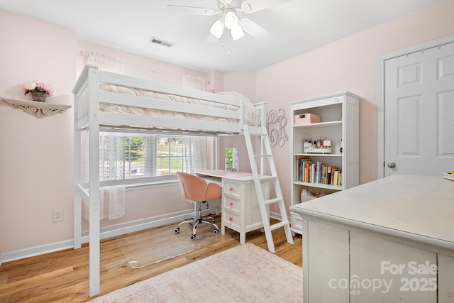 bedroom with baseboards, light wood-style flooring, visible vents, and ceiling fan