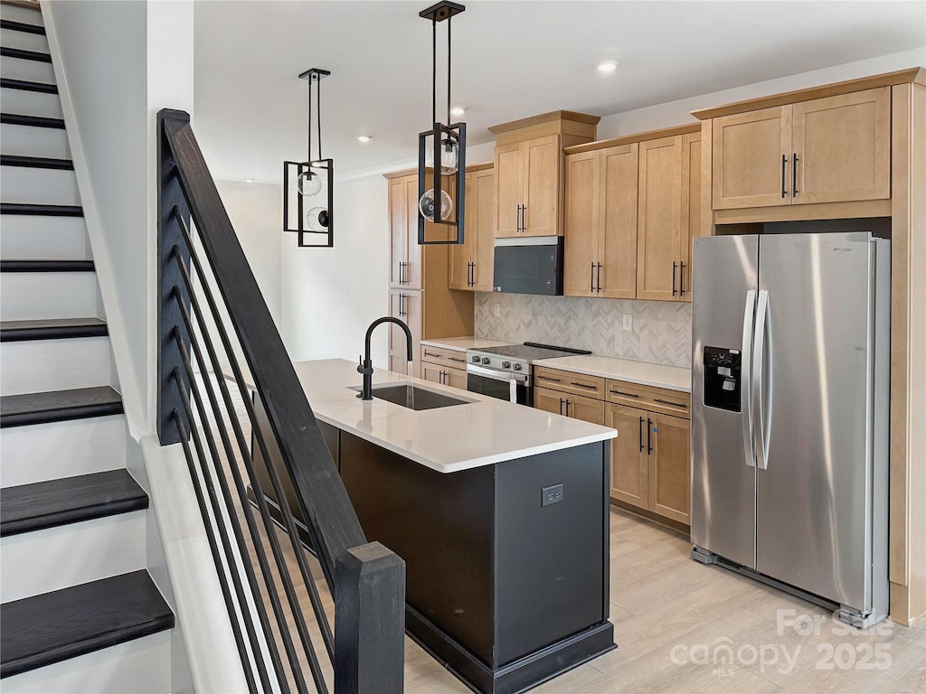 kitchen featuring decorative backsplash, light wood-style flooring, a sink, appliances with stainless steel finishes, and light countertops