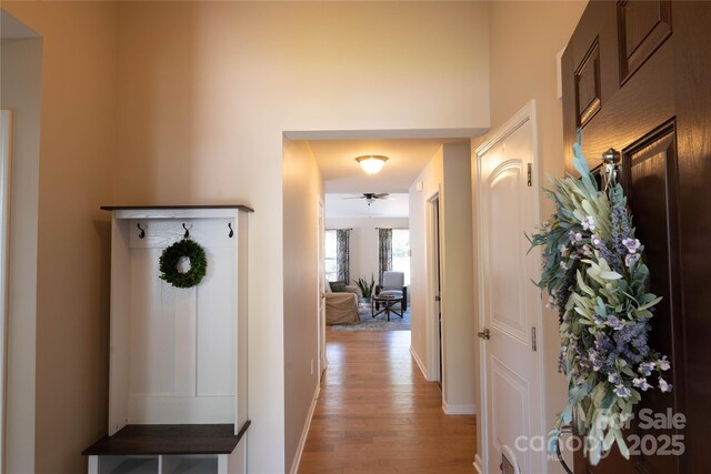 corridor featuring light wood-type flooring and baseboards