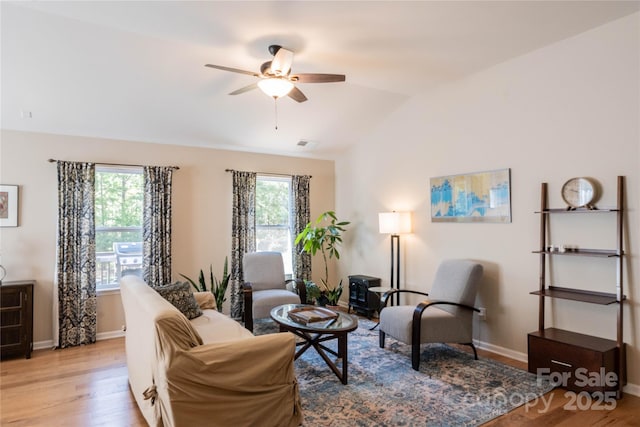 living room with wood finished floors, a ceiling fan, and plenty of natural light